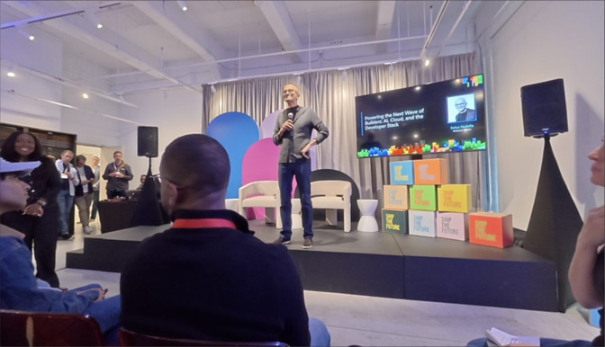 Satya Nadella s mikrofónom na pódiu pred publikom